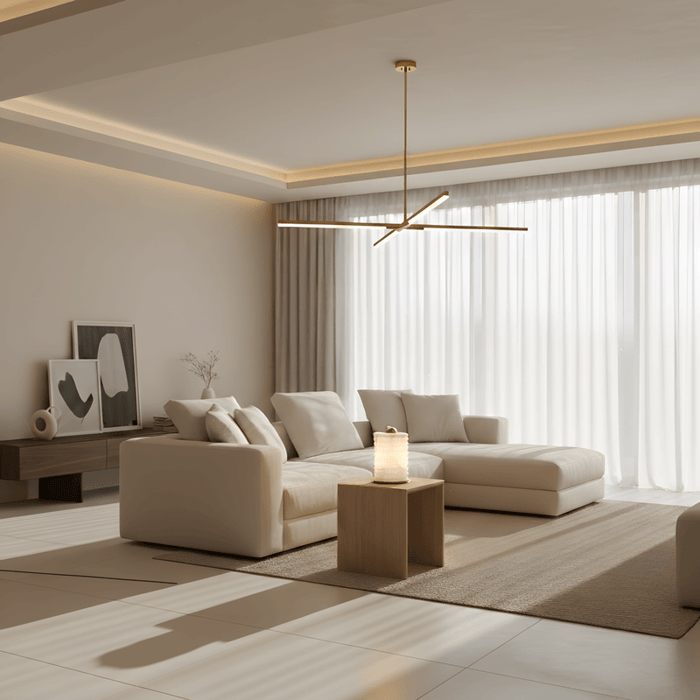 Minimalist living room with sculptural pendant light, neutral sectional sofa, and soft indirect ceiling lighting.