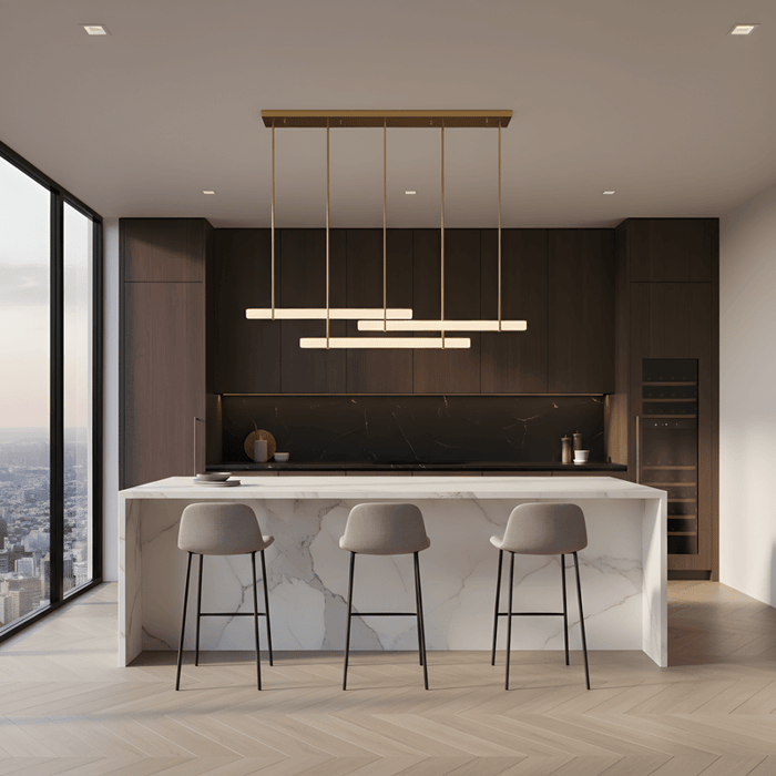 Modern kitchen with marble island and linear pendant lighting in a minimalist interior with dark wood cabinetry.