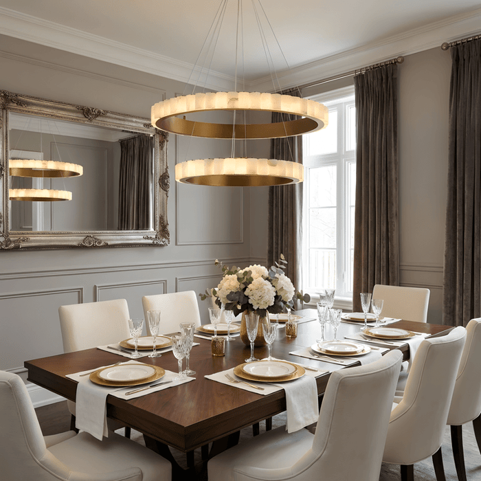 Elegant dining room with double ring chandelier, wooden table, upholstered chairs, and classic wall panelling.