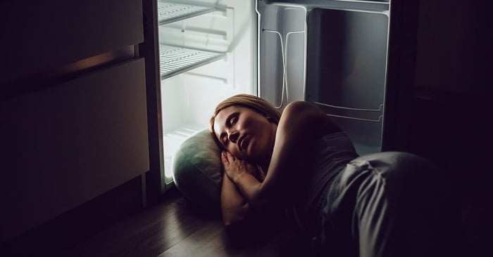 Woman waking up overheated in bed, experiencing night sweats in women due to temperature changes.