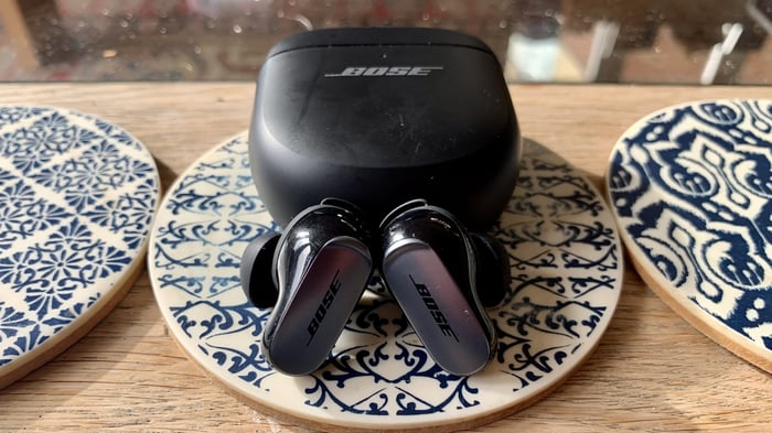 Bose QuietComfort Ultra Earbuds on a coffee table with the case
