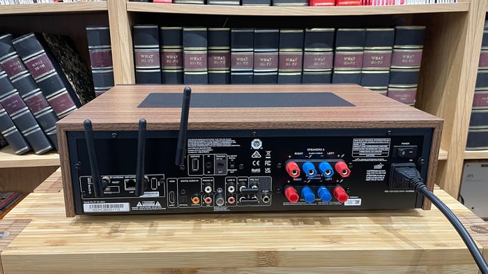 NAD C 3050 with MDC2 BluOS-D module streaming amplifier in front of bookcase