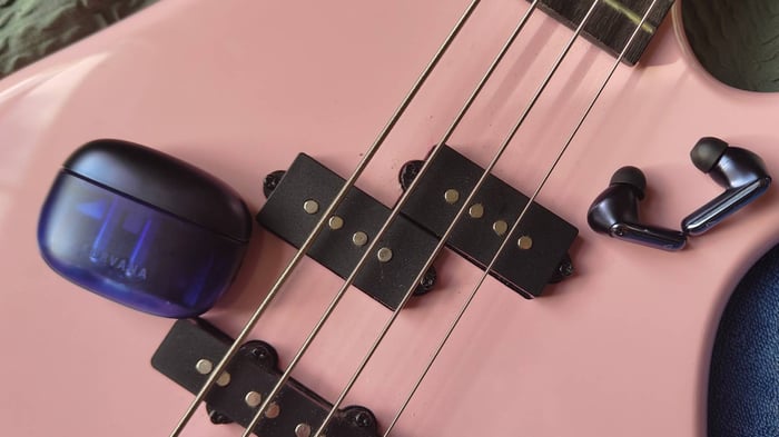 Creative Aurvana Ace 3 earbuds and case on a pink bass guitar