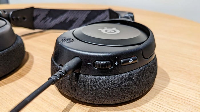 A close-up of the left earcup shows intuitive control layout and the retractable microphone.