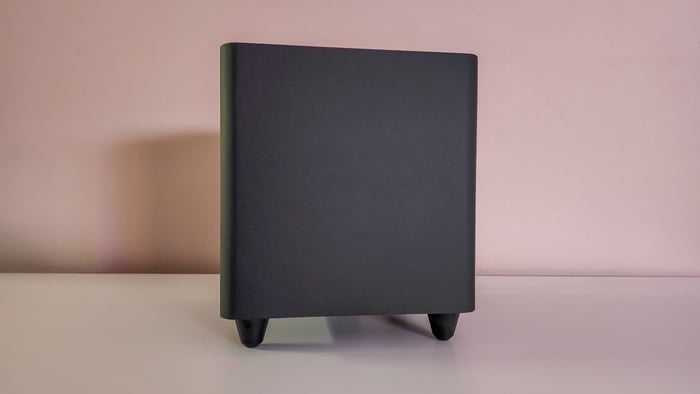 The elevated soundbar fits snugly above a monitor stand, saving desk space.