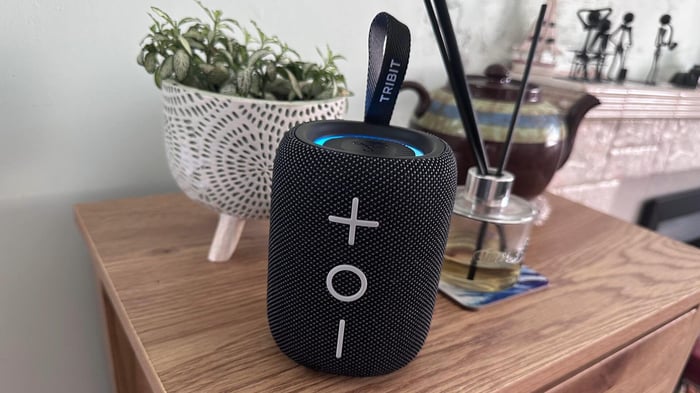 Tribit Stormbox Mini Plus resting on a wooden table—small but sturdy.