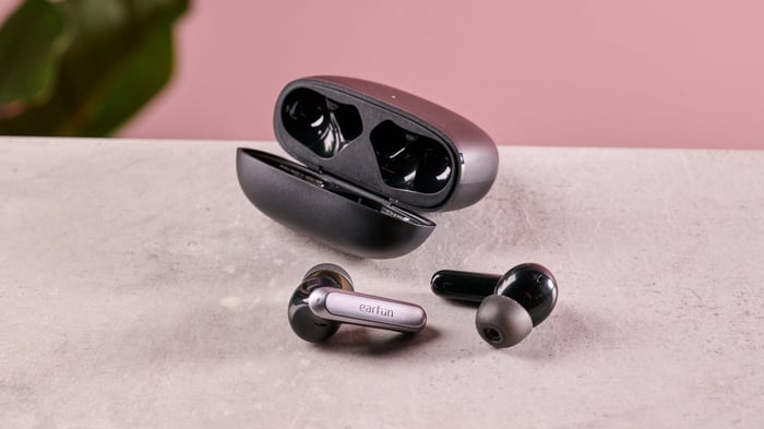 EarFun Air 2 NC earbuds and charging case on a pink surface