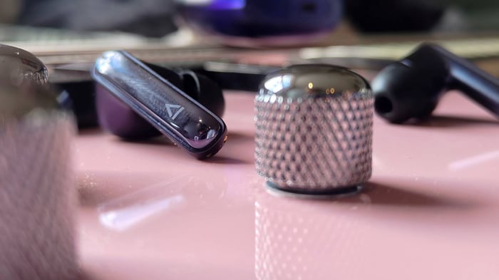 Creative Aurvana Ace 3 buds on a pink bass guitar