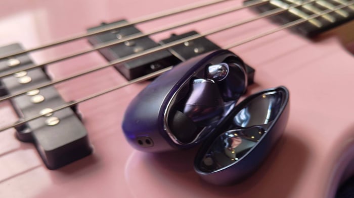 Creative Aurvana Ace 3 buds and case on a pink bass guitar