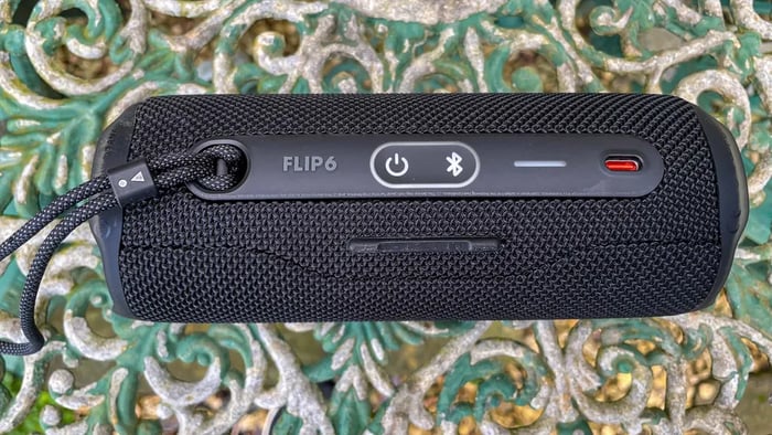 Side profile showing carry strap and cylindrical design