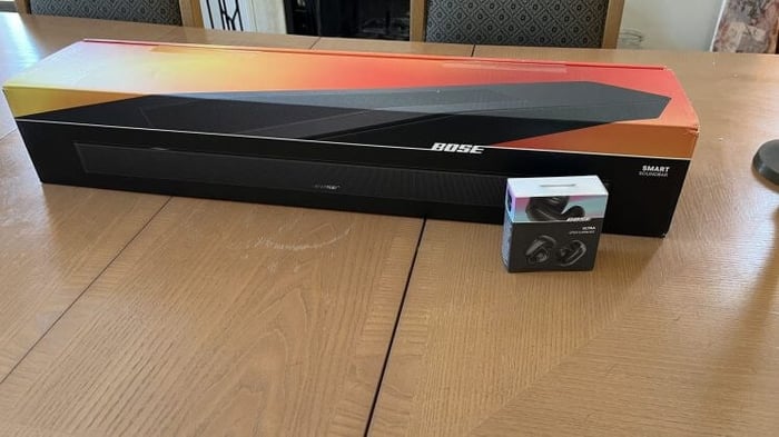 Bose Smart Soundbar boxed with Bose earbuds.