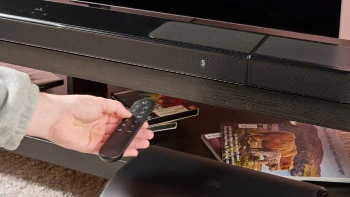 Man using remote on JBL Bar 1300MK2.