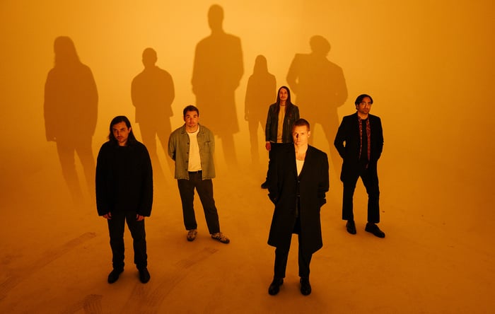 Deafheaven photographed against an orange background, photo by Nedda Afsari