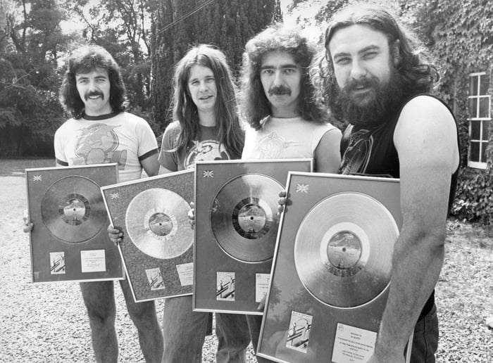 Tony Iommi, Ozzy Osbourne, Geezer Butler and Bill Ward of Black Sabbath with the silver discs they received for the album 'Technical Ecstasy' in 1977.