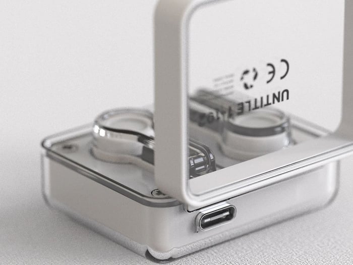 Earbuds held gently in hand, showcasing their ergonomic shape.