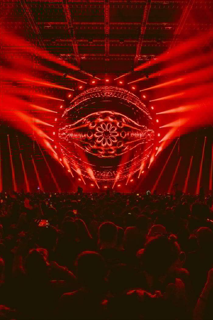 Rezz immersed in her sonic realm, eyes glowing with intensity.