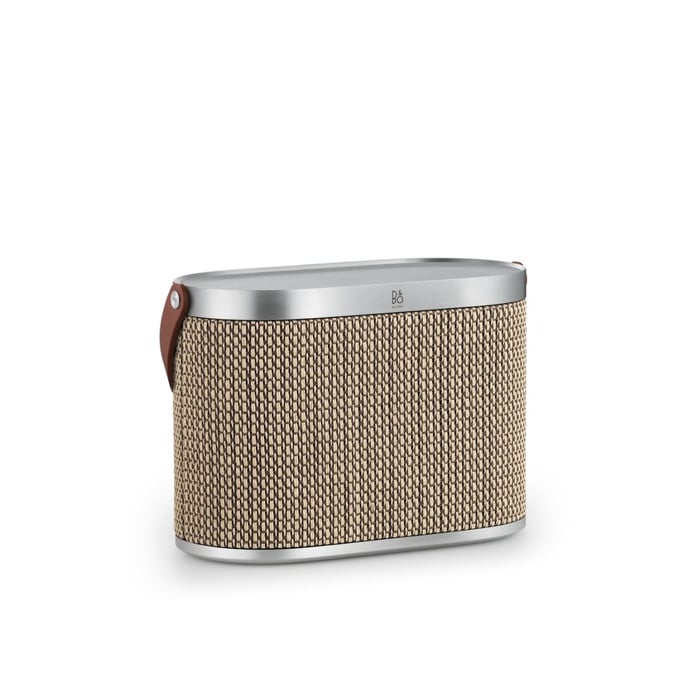 Beoplay H100 headphones resting on matching accessories