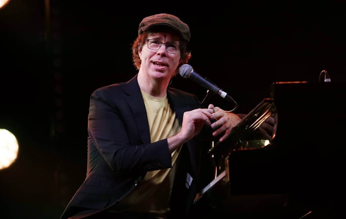 Ben Folds playing piano passionately during a performance