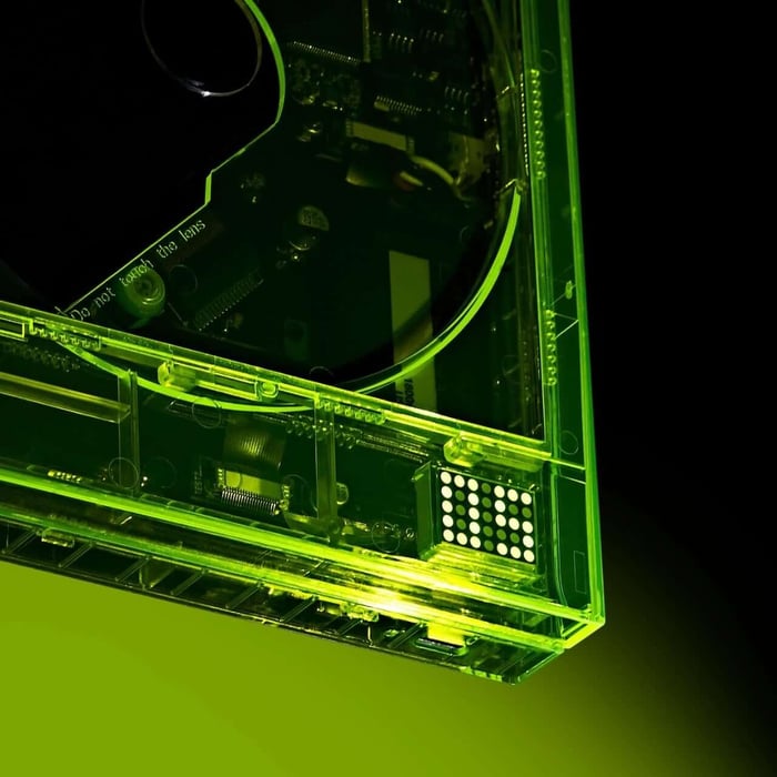 The neon yellow CD player glowing vibrantly with exposed internal components