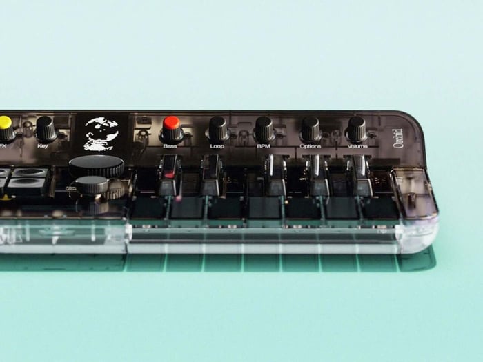 Detailed view of the Orchid Arctic’s yellow knobs and red Bass button set against the dark control surface