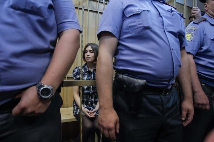 Pussy Rioter Nadezhda Tolokonnikova is seen behind the bars during a trial in Tagansky court in Moscow. (Credit: Denis Sinyakov)