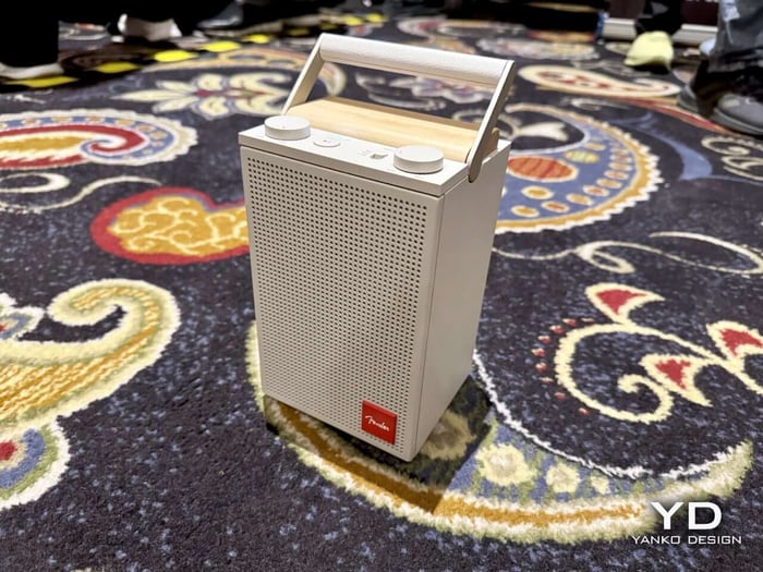 Close-up of the wooden fretboard handle and perforated speaker grille