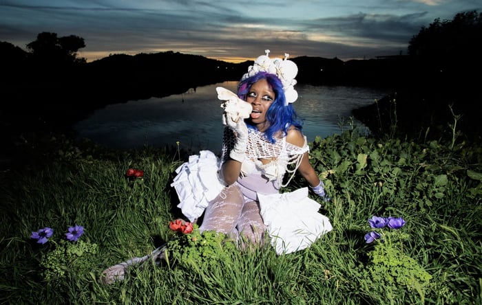 Hemlocke Springs with colorful hair and radiant styling, embodying her vibrant alt-pop persona.