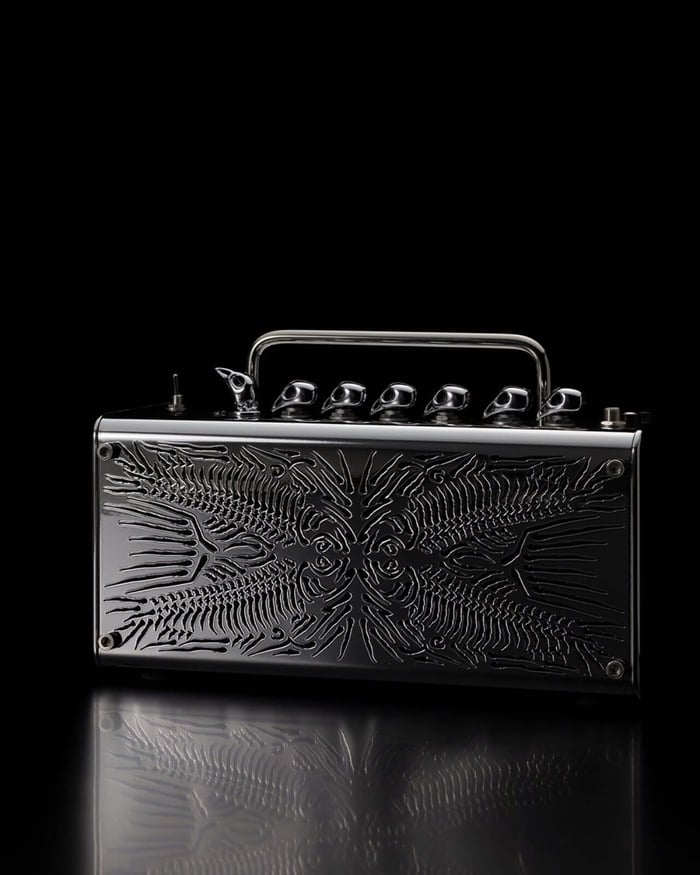 Side view showcasing the amplifier’s intricate fish skeleton grille and bird-head knobs