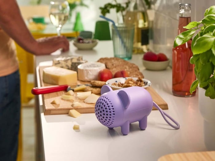 Purple mouse speaker on a shelf surrounded by toys