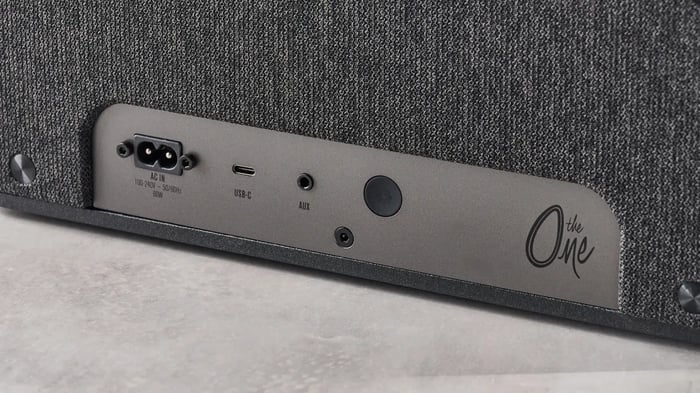 Minimalist top panel with volume knob and source button for clean aesthetics.