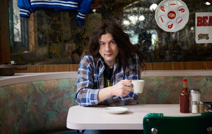 Kurt Vile smiling in a press portrait