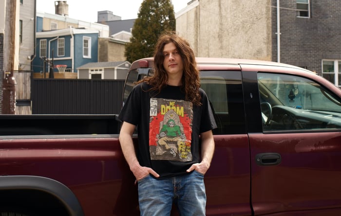 Kurt Vile performing with his band under stage lights