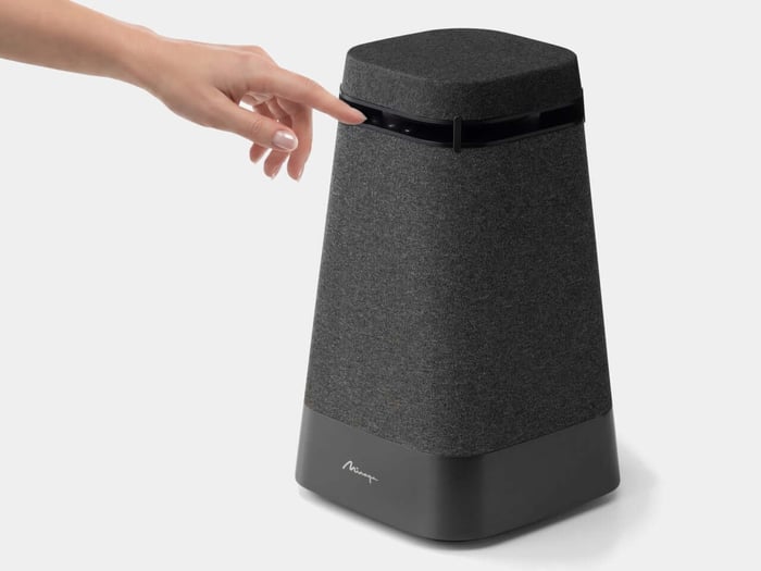 Speaker shown on a table, blending into modern living room settings