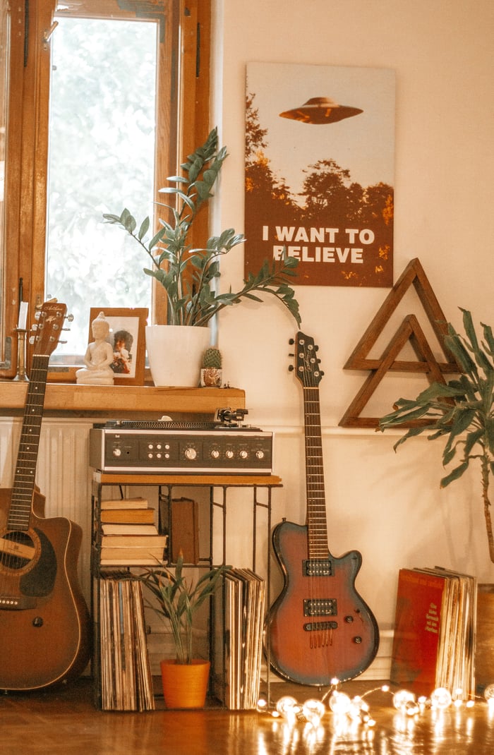 Warm music room with guitars, records, plants, and a wall poster as interior inspiration