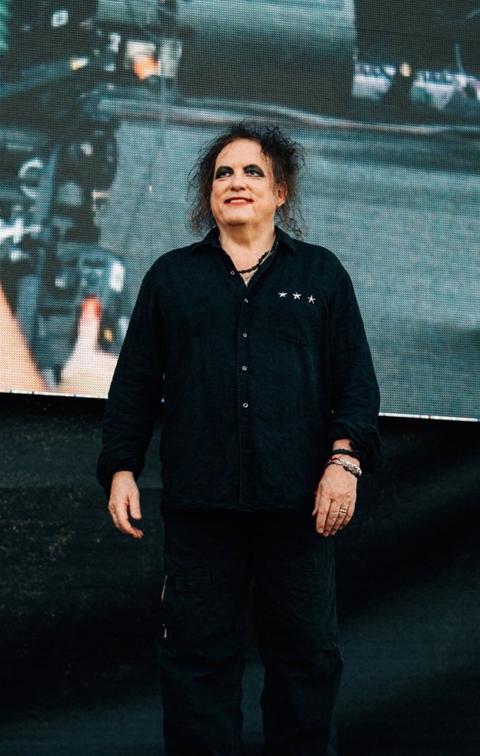 Robert Smith glowing under stage lights, Cardiff 2026