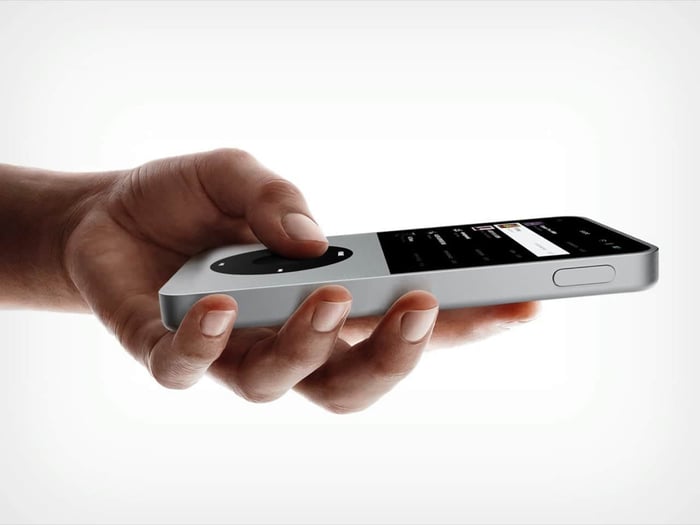 Silver Sudo music player held in one hand, thumb resting on the tactile wheel