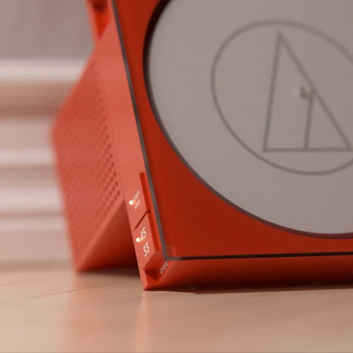 Watching the record spin behind orange-tinted glass turns music into art.