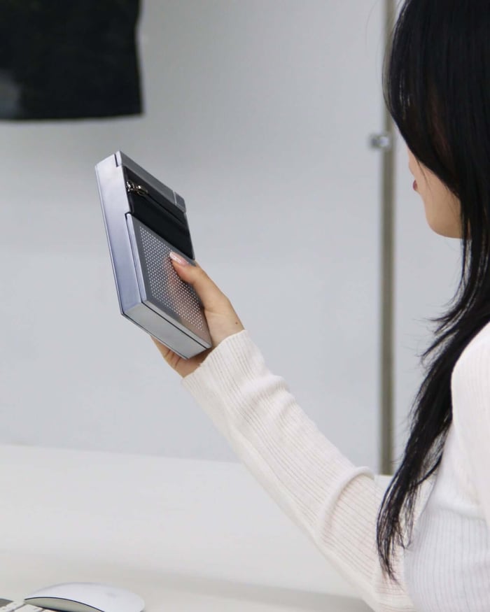 Person demonstrating ZIP speaker’s zipper interface over mouth