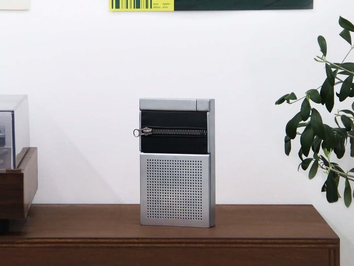 ZIP concept speaker with silver body and dark fabric band featuring a metal zipper