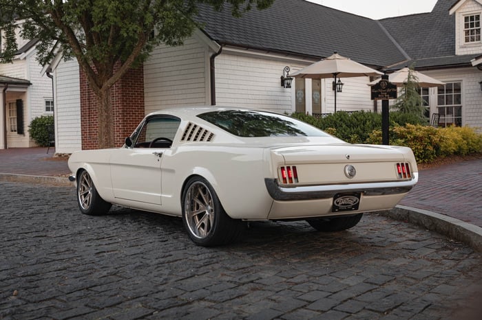 A side profile of the Mustang showcases its hand-crafted sheet metal flares and flush-mounted glass for a seamless, modern look.
