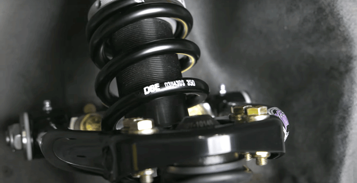 High-performance coilover kit from Detroit Speed bolted onto a factory suspension.