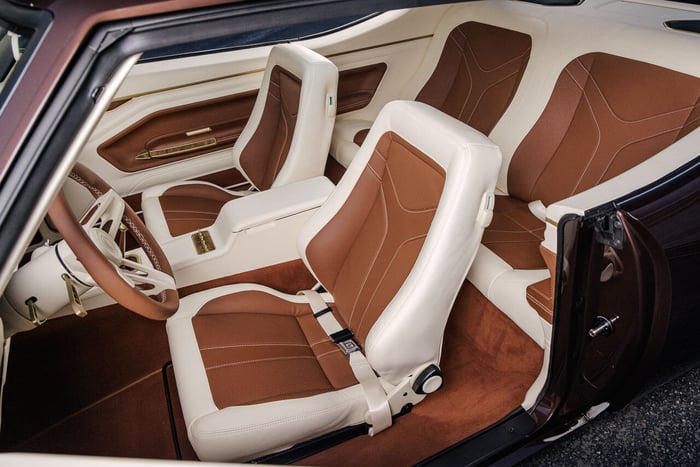 Interior of Kevin Hart’s GTO showcasing cream leather upholstery, custom Classic Instruments gauges with gold accents, and a Hurst shifter with a Bowler Performance knob.
