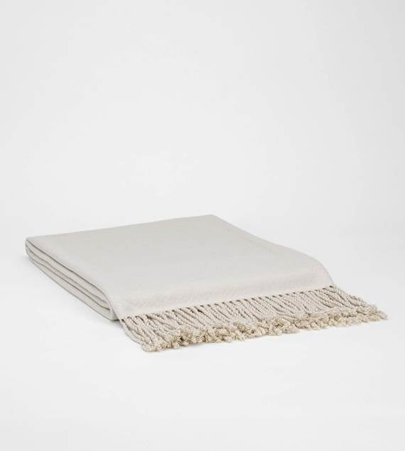A white blanket with fringeAI-generated content may be incorrect.