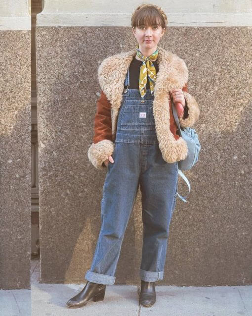 Woman wears a Y2K style jacket over overalls with a bandana around her neck.