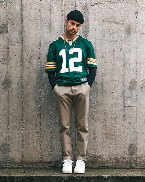 man wearing a beanie standing by a wall