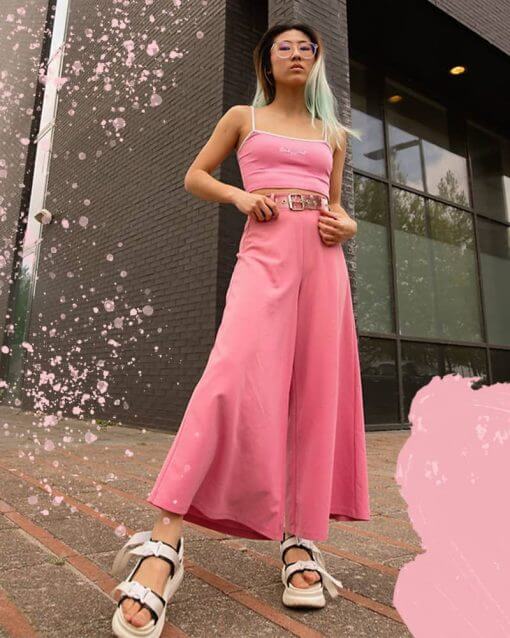 Woman wears a monochromatic pink outfit with a crop top.