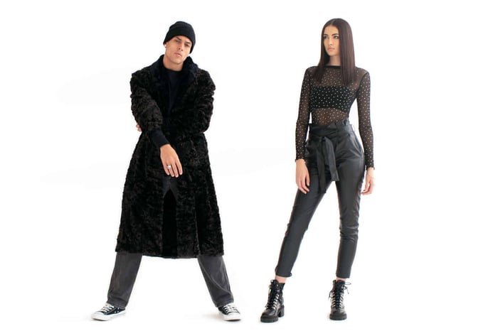 Man and woman standing apart from each other wearing all black