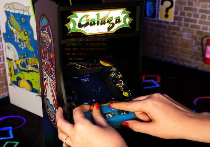 Player on the Galaga quarter arcade machine