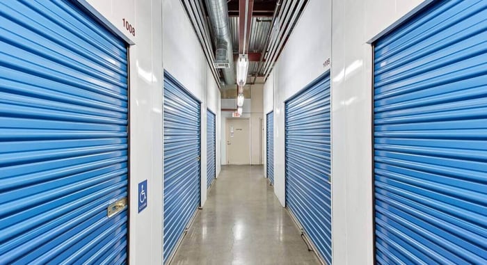 A well-organized 10x10 storage unit filled with furniture, boxes, and appliances, demonstrating the ideal storage capacity. STORAGExperts in Covina, California.