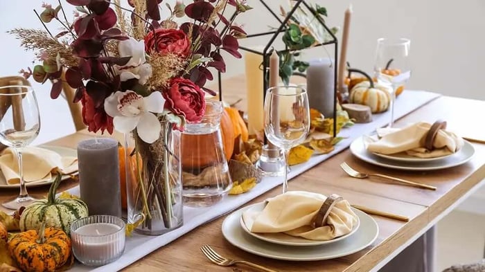 a table decorated for fall with pumpkins and gourds